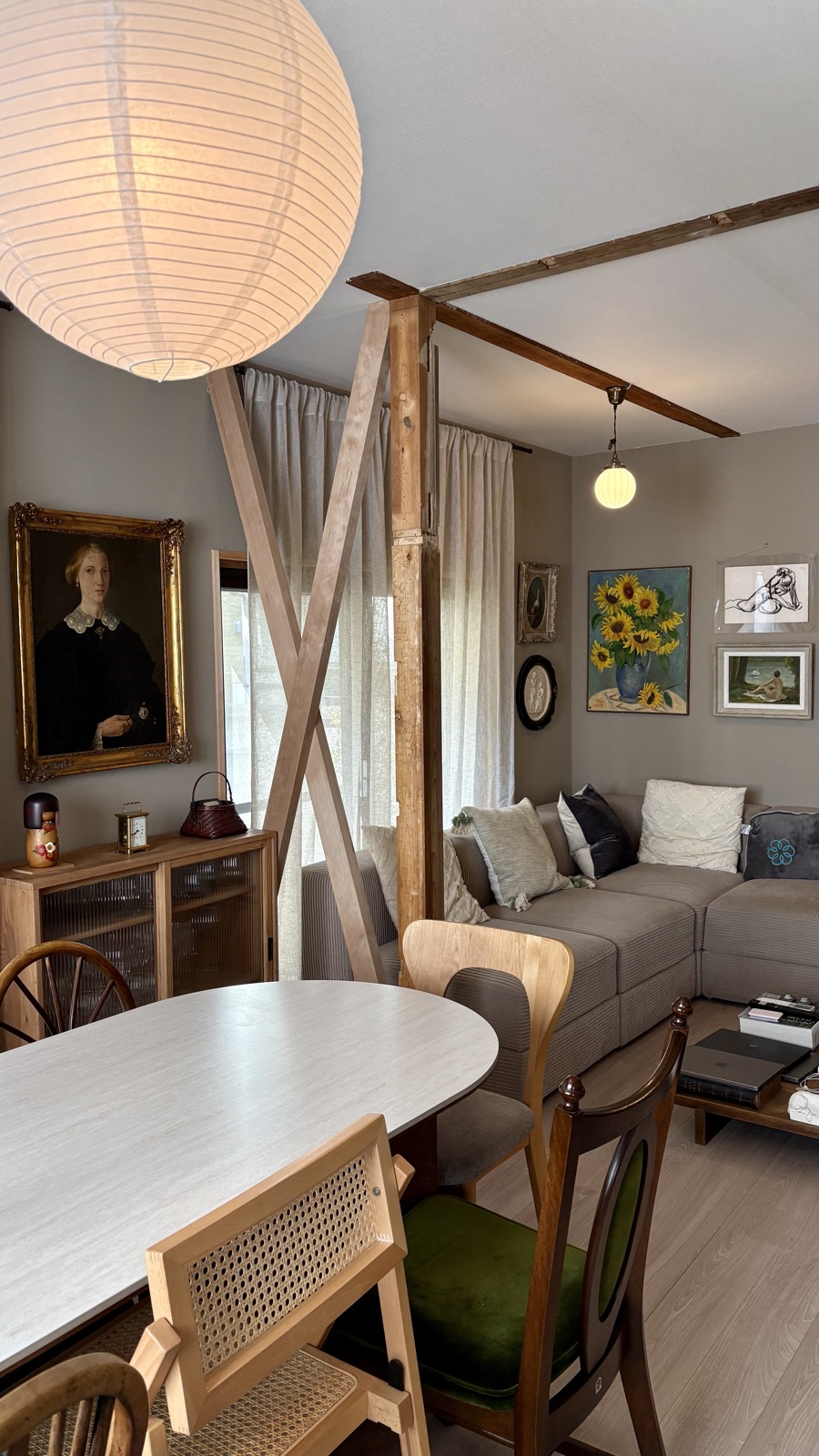 Restored living and dining room with paper lantern and vintage art
