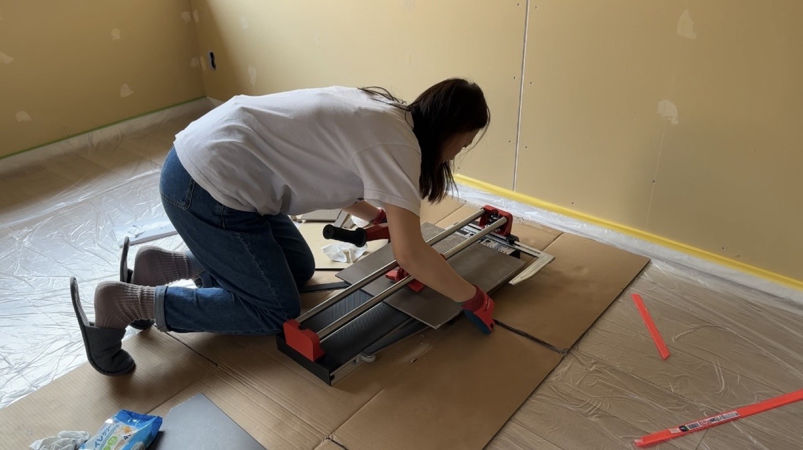 Misaki cutting tiles by hand during akiya bathroom restoration
